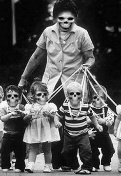 an old black and white photo of a woman holding strings with children in front of her