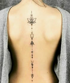 the back of a woman's body with tattoos on her upper and lower back