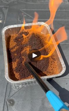 a metal pan filled with food on top of a table next to a blue spatula