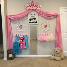 there is a pink and blue room with princess decorations on the wall, teddy bear sitting in front of it