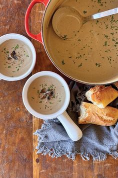 two bowls of soup and bread on a wooden table