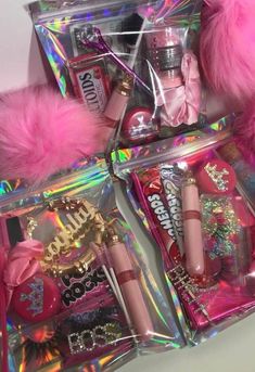 the contents of an assortment of cosmetics and makeup products are displayed in plastic bags with pink fur pom - poms