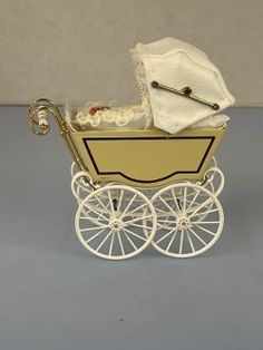 a white and yellow baby carriage on a gray surface