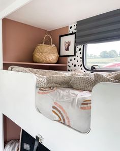 a bunk bed in a small room with pink walls and black and white decor on the wall