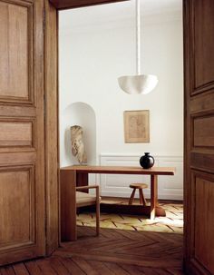 an open door leading to a dining room with a table and chairs in the corner