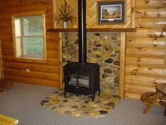 a log cabin with a wood stove in the corner