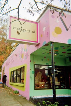 a pink and green building with an ice cream shop on the front window that says vintage pink