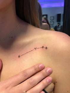 a woman's chest with the word love written in small stars on her left side