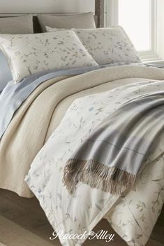 the comforter is made up with blue and white sheets, pillows, and blankets