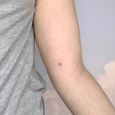 a person with a small star tattoo on their arm