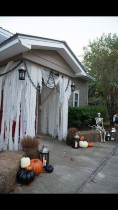 an outdoor halloween scene with pumpkins and decorations