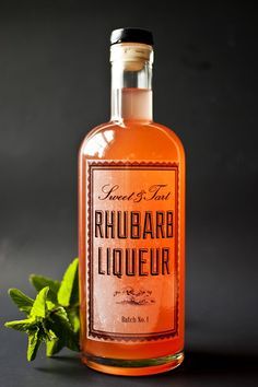 a bottle of rhubarb liquor next to some leaves