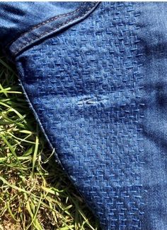 a pair of blue jeans laying on top of grass