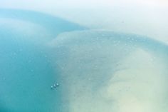 an aerial view of the water and sand from a plane flying in the sky above