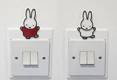 two white light switches with cartoon rabbits on each one and an outlet in the middle