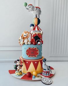 a multi layer cake with circus animals on top