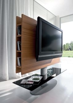 an entertainment center with a television and dvd's on the shelf, in front of a window