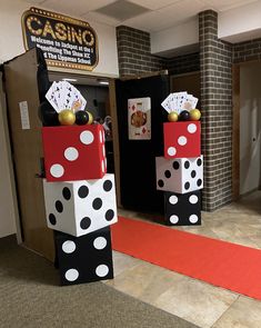 two cardboard blocks with dices and playing cards on them in front of a casino sign