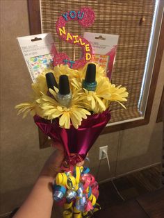 someone is holding a bouquet of flowers in front of a sign that says happy birthday