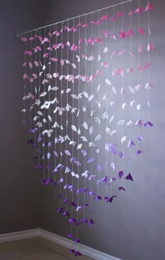 a mobile made out of paper butterflies hanging from the side of a wall in a room