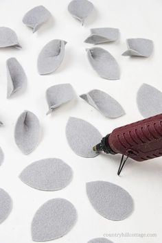 a close up of a crafting machine with paper petals on the table next to it