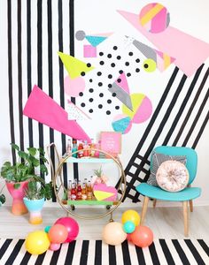 a room with black and white striped walls, colorful decorations and balloons on the floor