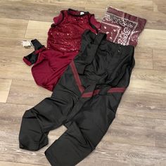 two pieces of clothing laying on the floor next to each other, one red and one black