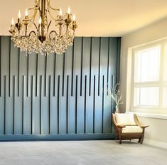 a chandelier hangs from the ceiling in an empty room with blue paneling