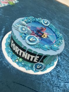 a cake that is sitting on top of a blue tablecloth with the name fortnite