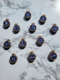 twelve zodiac signs in gold and blue on a marble surface