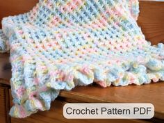 a crocheted blanket sitting on top of a wooden bench