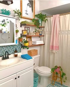 a white toilet sitting next to a bathroom sink under a mirror and a shower curtain