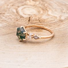 a close up of a ring on a piece of wood with a stone in the middle