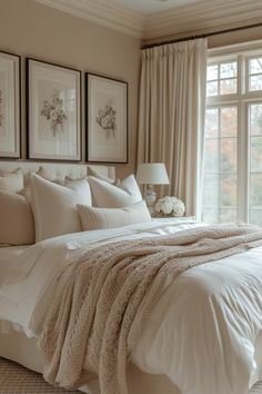 a large bed sitting in a bedroom next to two framed pictures on the wall above it