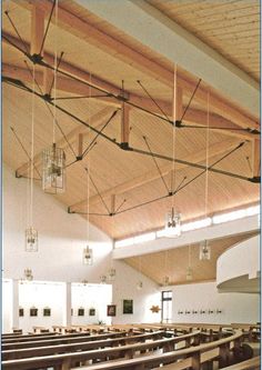 an empty church with wooden pews and chandeliers