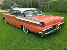 an orange and white car parked in the grass