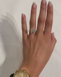 a woman's hand with a gold watch and diamond ring on her left wrist