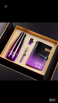 a purple and black gift box containing an audi pen, notepad, lighter and notebook