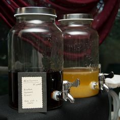 there are two jars with drinks in them on top of a black object that has a label attached to it