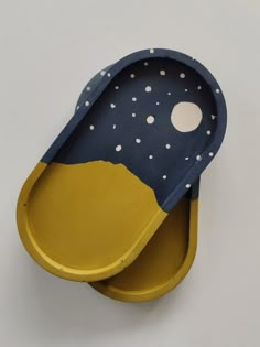 two yellow and blue trays sitting on top of each other with white polka dots