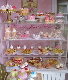 a display case filled with lots of different types of cakes and cupcakes on it