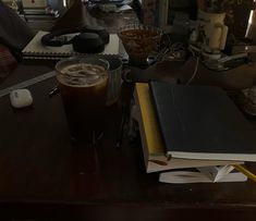 a desk with a book, coffee cup and other items on it