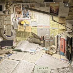 many books and papers are spread out on a desk with a lamp, telephone, and other items