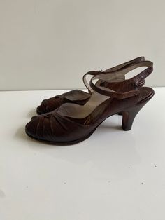 "Vintage 1950s Palizzio New York Leather Sandals Free Shipping These vintage heeled sandals are leather uppers. They are in good vintage condition and have new heel tops and new leather soles. They are tiny. The sole on the inside is just under 9.5\" long and the ball of the foot is 3\" across. The surface of the leather is embossed and could be reptile skin. The brand is Palizzio New York.  I believe them to be a size 6 or 6.5." Retro Sandals With Leather Sole, Retro Closed Toe Sandals With Leather Sole, Retro Leather Sandals With Leather Sole, Vintage Heels With 4-inch Heel And Round Toe, Retro Sandals With Wooden Open Heel, Vintage Leather Sandals With Round Toe, Retro Closed Toe Sandals With Wooden Heel, Vintage Brown Sandals With Wooden Heel, Vintage Heels With Penny Strap And Almond Toe