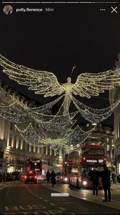 an image of a city street at night with christmas lights and angel decorations on it