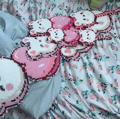 some hello kitty cupcakes on a bed with pink and white flowers around them