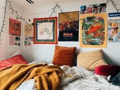 a bed with lots of pillows and pictures on the wall