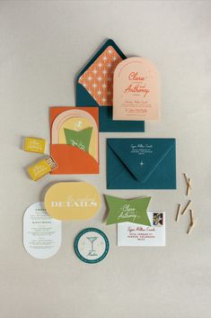 the wedding stationery is laid out on top of each other, including cards and envelopes