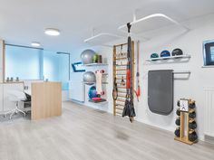 an office with white walls and hard wood flooring, sports equipment on the wall