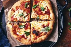 a pizza sitting on top of a pan covered in cheese and spinach toppings